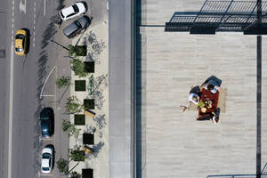 Aerial view of three people having a meal on the roof - EYAF00456