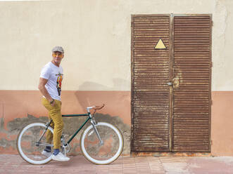 Mann mit Fixie-Fahrrad schaut in die Ferne - DLTSF00050