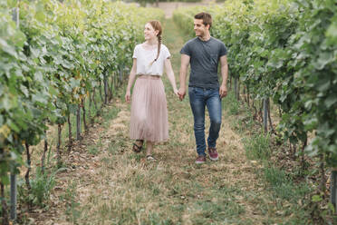 Glückliches junges Paar beim Spaziergang Hand in Hand in den Weinbergen - ALBF01022