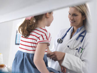 Ärztin untersucht und diagnostiziert ein junges Mädchen in einer Klinik - ABRF00617