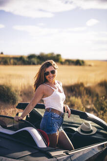 Sexy woman with sunglasses posing in her convertible - OCMF00611