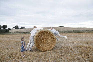 Father and his children playing on hay bales - KMKF01074