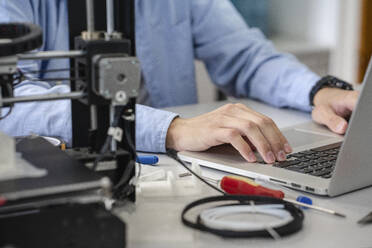 Student beim Einrichten eines 3D-Druckers, mit Laptop, Nahaufnahme - VPIF01458