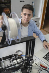 Student beim Einrichten eines 3D-Druckers mit Laptop - VPIF01464