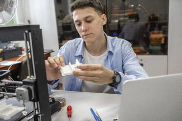 Student beim Einrichten eines 3D-Druckers mit Laptop - VPIF01483