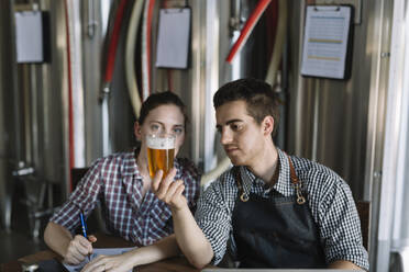 Young entrepreneurs working at a brewery testing beer - ALBF01058