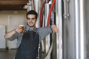 Porträt eines selbstbewussten jungen Mannes mit einem Bierglas in einer Brauerei - ALBF01077