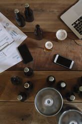Bierflaschen, Gläser, Dokumente, Smartphones und Laptop auf dem Tisch - ALBF01092