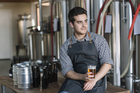 Young man drinking a beer at a brewery - ALBF01097