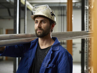 Porträt eines Arbeiters, der Aluminiumrohre trägt - CVF01481