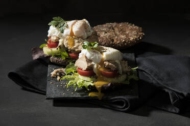 Close-up of open faced sandwich served on table against black background - MAEF12929