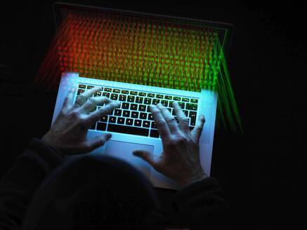 Cyberkriminalität, Ein Hacker, der einen Virus benutzt, um Software anzugreifen - ABRF00636