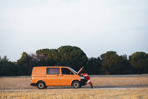 Santa Claus examining damaged van on country road - JCMF00182