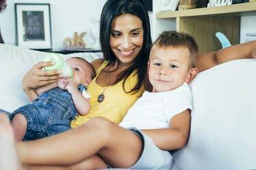 Mother with her two sons sitting on a sofa - OCMF00620