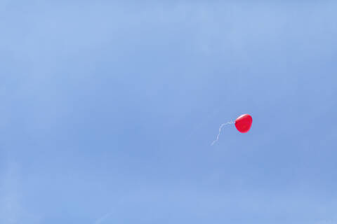 Niedrigen Winkel Ansicht der roten herzförmigen Ballon fliegen gegen klaren blauen Himmel bei der Hochzeitsfeier, lizenzfreies Stockfoto