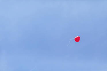 Niedrigen Winkel Ansicht der roten herzförmigen Ballon fliegen gegen klaren blauen Himmel bei der Hochzeitsfeier - MMAF01108