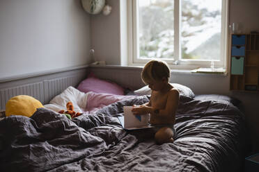 Boy reading on bed - JOHF00021