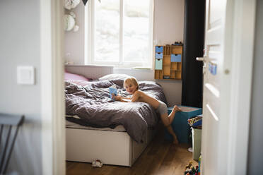 Boy playing on bed - JOHF00086