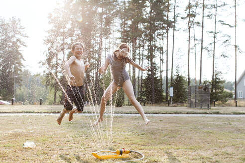 Fröhliche Kinder spielen mit Wasser - JOHF00108