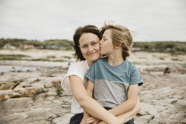 Mother and son kissing at seaside - JOHF00134