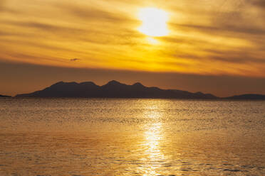 Silhouette der Insel Rum vor bewölktem Himmel bei Sonnenuntergang, Lochaber, Schottland, UK - SMAF01474