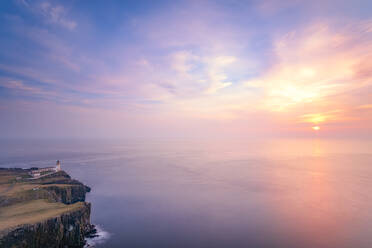 Neist Point Leuchtturm am Meer gegen bewölkten Himmel bei Sonnenuntergang in Waterstein, Isle of Skye, Highlands, Schottland, UK - SMAF01492