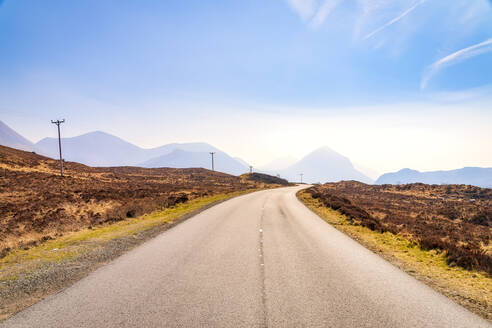 Abnehmende Ansicht der leeren Straße A863 mit den Cuillin-Bergen im Hintergrund, Isle of Skye, Highlands, Schottland, UK - SMAF01505