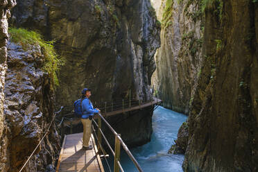 Seitenansicht einer älteren Frau auf einem Steg am Wasserfallsteig in der Leutaschklamm, Tirol, Österreich - SIEF09006