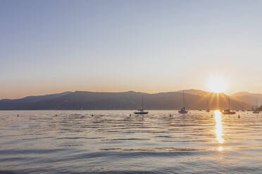Segelboote auf dem Lago Maggiore gegen den klaren Himmel bei Sonnenuntergang, Ispra, Italien - MMAF01112