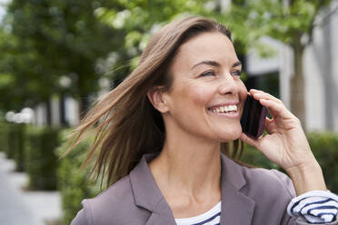 Happy businesswoman on the phone in the city - PNEF01854