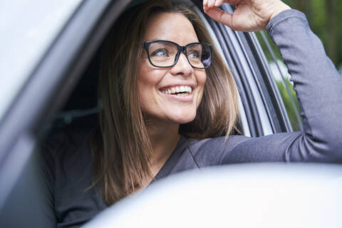 Porträt einer lächelnden Frau in einem Auto, lizenzfreies Stockfoto