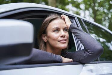 Frau in einem Auto mit Blick zur Seite - PNEF01889