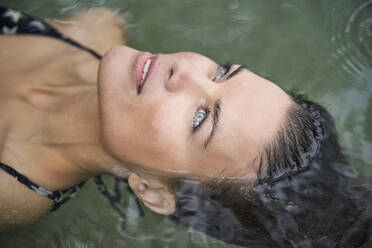 Portrait of woman floating in water - PNEF01925