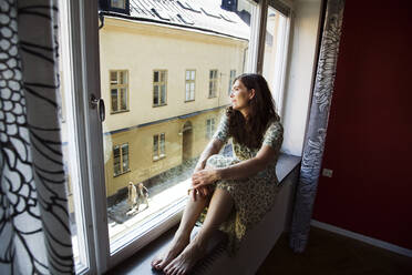 Woman looking through window - FOLF10338