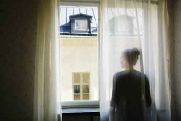 Woman looking through window - FOLF10339