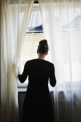 Woman looking through window - FOLF10340