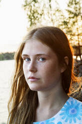 Porträt einer jungen Frau mit See im Hintergrund - FOLF10359