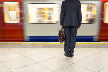 Geschäftsmann wartet auf U-Bahn-Zug am Bahnhof in London, Vereinigtes Königreich, England - FOLF10374
