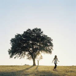 Zwei Kinder (6-7, 10-11) bei einem Baum auf einem Feld in Portugal - FOLF10384