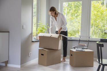 Woman unpacking cardboard box - FOLF10462