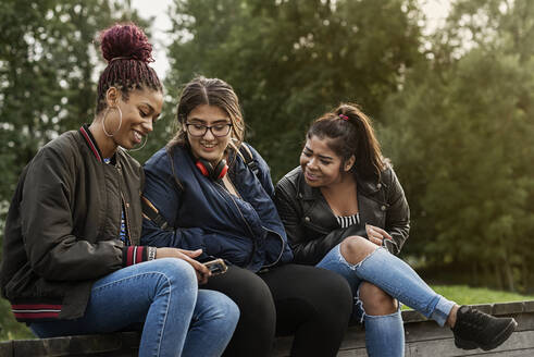 Mädchen im Teenageralter benutzen ein Smartphone - FOLF10560