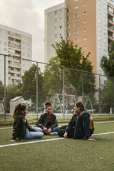 Teenager-Mädchen sitzen auf dem Tennisplatz - FOLF10561