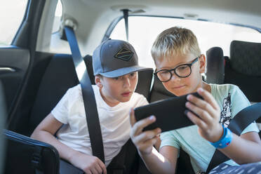 Jungen mit Smartphone im Auto - FOLF10589