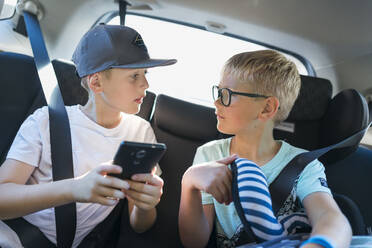 Jungen mit Smartphone im Auto - FOLF10590