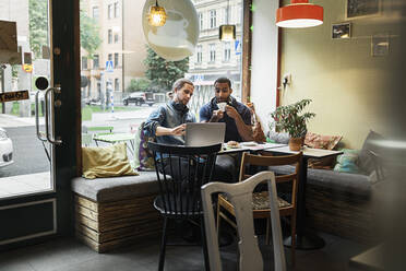 Junge Männer arbeiten zusammen in einem Café - FOLF10604