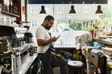 Mittlerer erwachsener Mann arbeitet in einem Café - FOLF10606