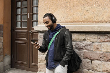 Young man listening to music outdoors - FOLF10615