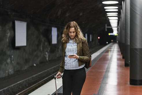 Junge Frau mit Koffer in der U-Bahn-Station - FOLF10658