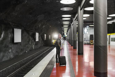 Junge Frau mit Koffer in der U-Bahn-Station - FOLF10659