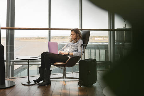Frau benutzt Laptop im Flughafen - FOLF10663